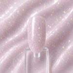 Rubber Base AuraNude N9, bază rubber nude aplicată pe o mostră ovală de culoare pentru unghii, cu textura produsului în fundal