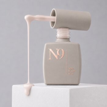 Bază rubber pentru unghii Soft Almond N9, 12 ml, în sticlă deschisă, cu produsul în nuanța Soft Almond curgând de pe pensulă