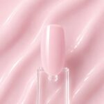 Rubber Base Pink Peach N9, bază roz-piersică aplicată pe o mostră ovală de culoare pentru unghii, cu textura produsului în fundal