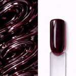 Top Coat roșu pigmentat Grape Syrup N9 aplicat pe o mostră ovală pentru unghii, cu finisaj lucios și textura nuanței în fundal